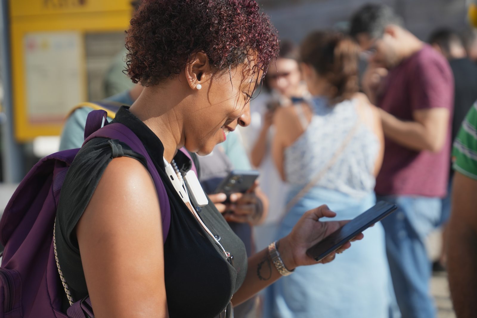 A player smiling at her phone during a GoQuestIRL adventure in Lisbon