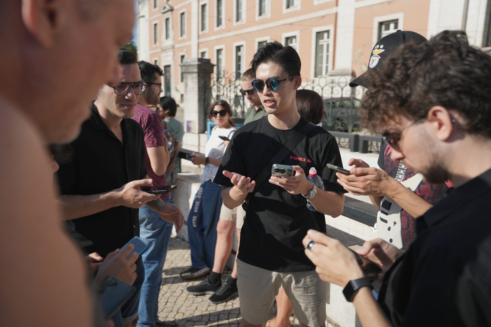 A group of players huddled around their phones, talking through a clue in Lisbon