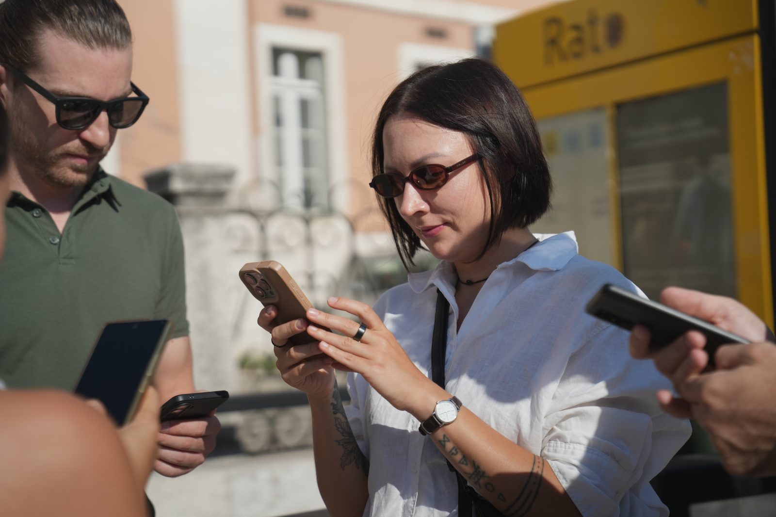 A small team of players checking their phones together outside a Lisbon metro entrance